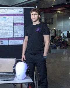Yaroslav next to the SeizAI poster and prototype